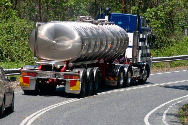 A photo of a tanker truck driving on a road.