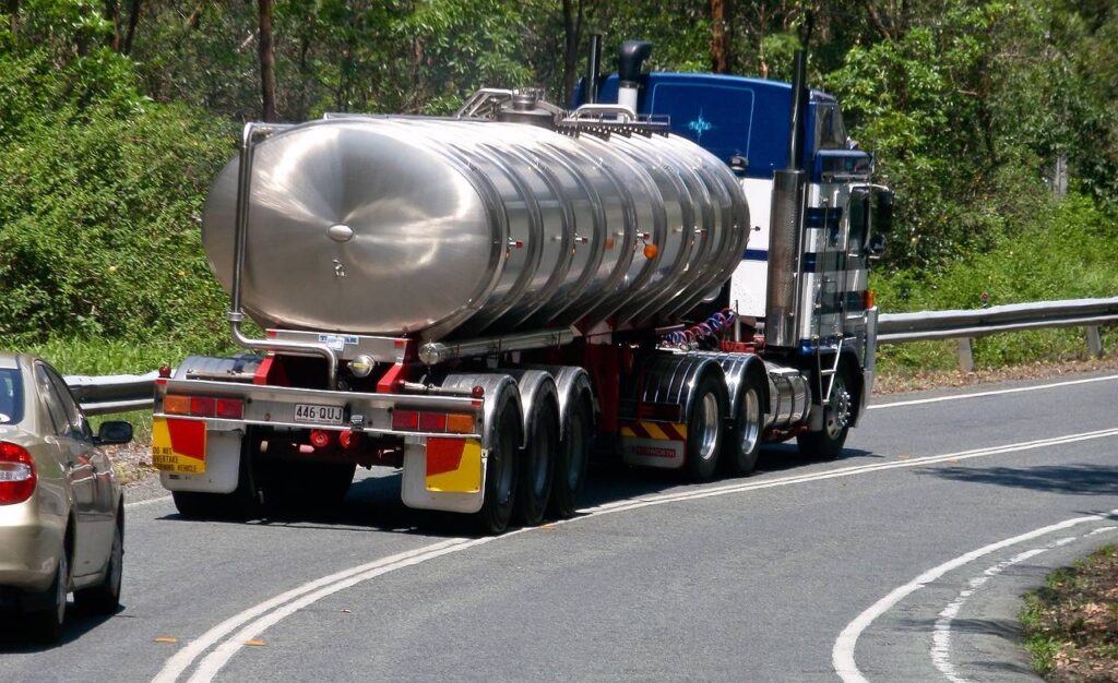 A photo of a tanker truck driving on a road.