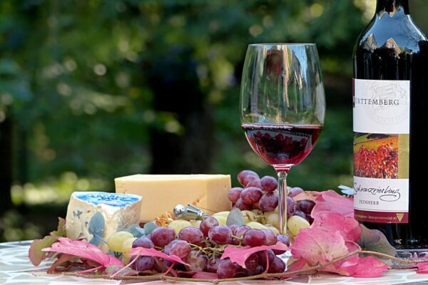 A picture of a cheese platter and red wine. Wine and cheese pairing.
