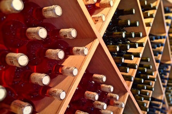 A photo of many wine bottles in a shelf.