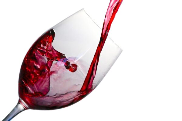 A photo of red wine being poured into a glass.