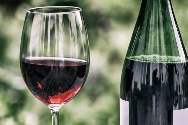 Photo of a glass and bottle of red wine.