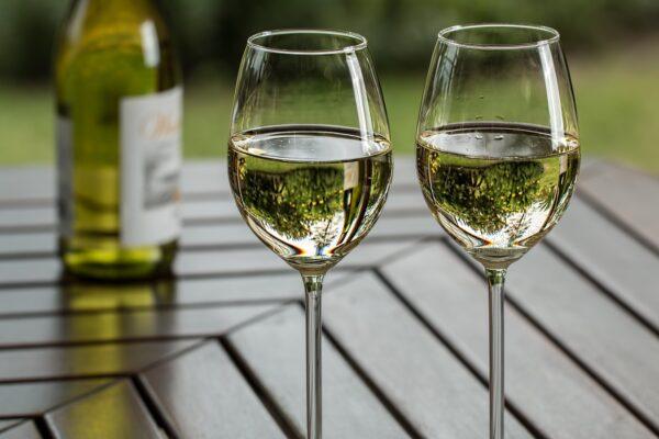 Photo of two white wine glasses on a table.