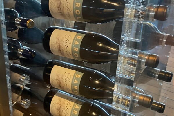 A picture of a wine fridge with bottles.