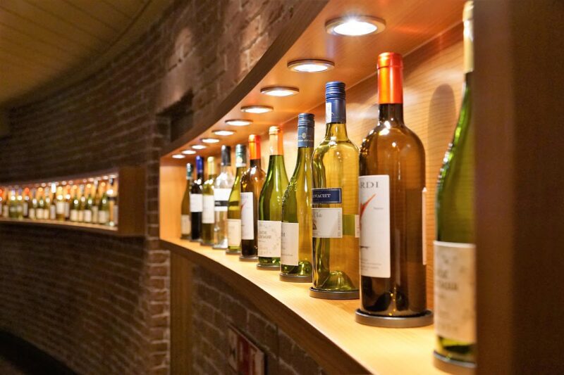 A picture of expensive wines on a brick shelf.