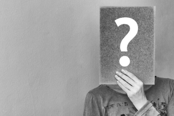 A man holding a question mark, wine myth busting.